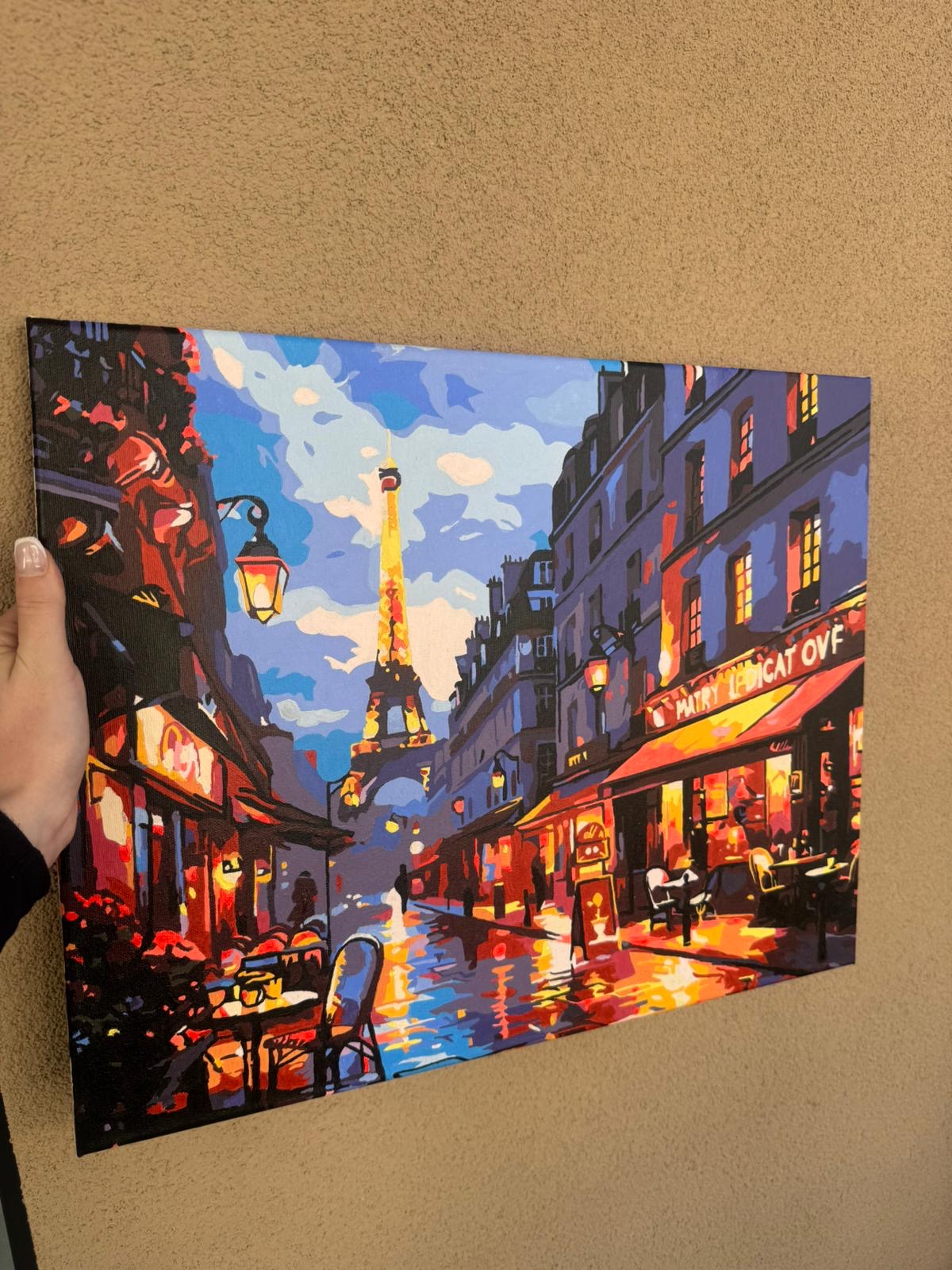 Tableau parisien accroché au mur, avec la tour Eiffel à l’horizon.