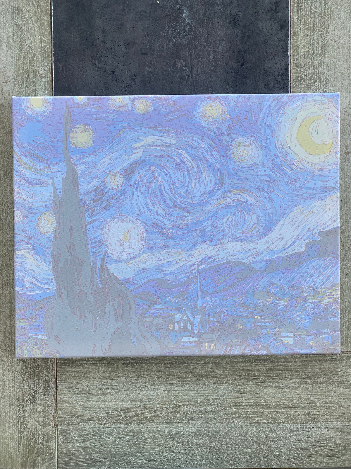 Toile représentant un ciel étoilé et un village.