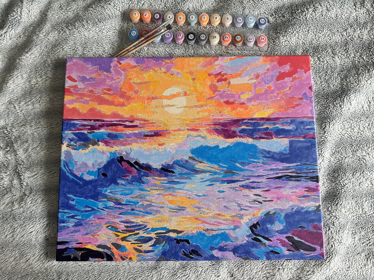 Coucher de soleil coloré sur les vagues, avec les pots de peinture et les pinceaux