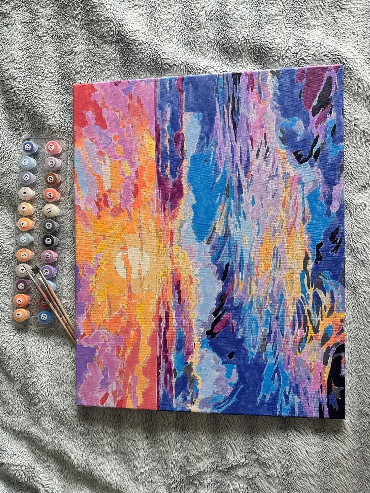 Tableau aux couleurs du coucher de soleil, photographié avec les pots de peinture.