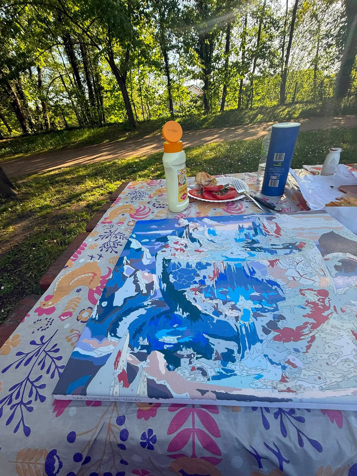 Tableau coloré posé sur une table dans un jardin.